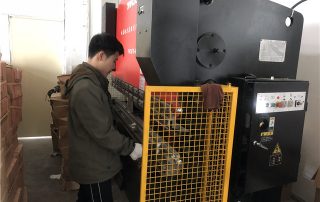 Workers work on Press Bracket Machine for TV bracket